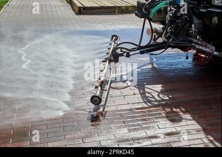 Eine spezielle Maschine wäscht Stadtwege und Straßen mit Wasser. Hochwertiges Foto Stockfoto