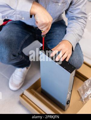 Computerspezialist. Hardware-Installation und Upgrades der Modem-Systemeinheit für das Internet mit Hilfe eines Schraubendrehers. Fokussierter junger männlicher Techniker tigh Stockfoto