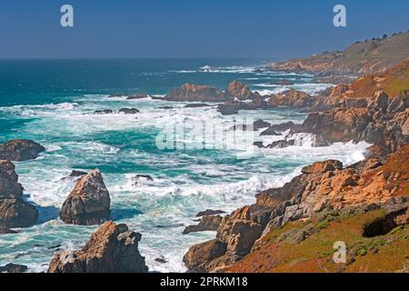 Seeschaum zwischen den Felsen an einer Hazy Coast im Andrew Molera State Park in Kalifornien Stockfoto