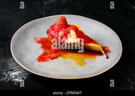 Teller mit süß gebackenen Birnen mit Mascarpone, Karamellsirup und Erdbeermarmelade Stockfoto