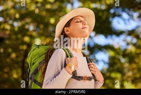 Frau, Atem und Rucksack in der Natur reisen für ein ruhiges, friedliches und entspannendes Abenteuer. Entspannter weiblicher Reisender, der frische Luft, Ausflug und Erkundungen genießt Stockfoto