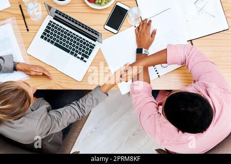 Vielen Dank für Ihren Beitrag zu diesem Projekt. Aufnahme aus einem hohen Winkel von zwei Geschäftsleuten, die sich während eines Meetings in einem Büro die Hand schütteln Stockfoto