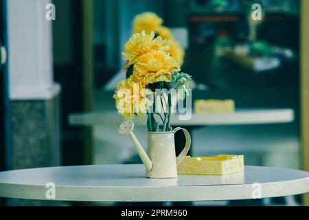 Vase, Töpfe, Gießkannen auf einem weißen Tisch Stockfoto