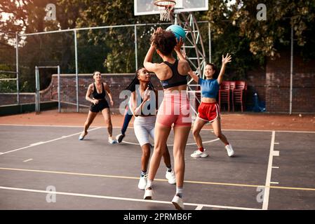 Ich musste hart für meine Spritze arbeiten. Eine vielfältige Gruppe von Sportlerinnen, die tagsüber gemeinsam ein Wettkampfspiel mit Basketball spielen Stockfoto