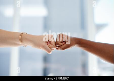 Teamwork macht den Traum wahr. Zwei unbekannte Geschäftsfrauen schlagen sich in einem Büro die Faust Stockfoto