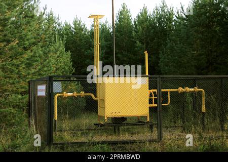 Gasverteilungspunkt, eingezäunt mit einem Netz im Wald. Das Konzept der Energiekrise, Mangel an Brennstoff. Übersetzung brennbar, Gas. Stockfoto