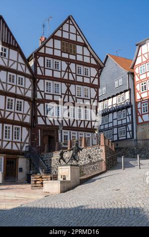 Schmale alte Fachwerkhäuser mit Wasserbrunnen im Vordergrund Stockfoto