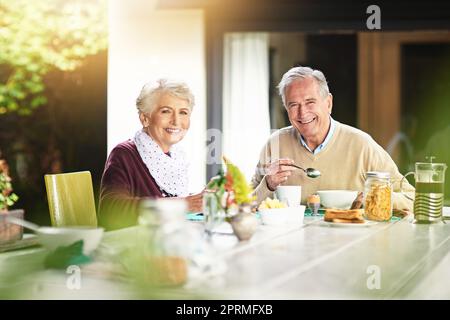 Es ist der beste Start in den Tag. Porträt eines glücklichen älteren Ehepaares, das zu Hause gemeinsam frühstücken kann. Stockfoto