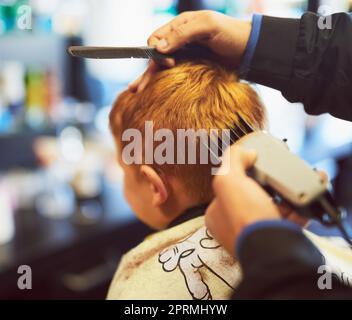 Kurz und elegant. Nahaufnahme eines Jungen, der in einem Friseurladen einen Haarschnitt bekommt. Stockfoto