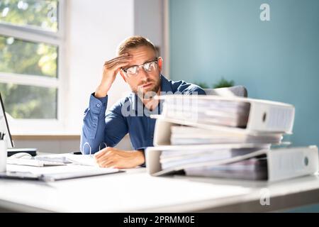 Langweiliger Arbeitshaholischer Buchhalter Stockfoto