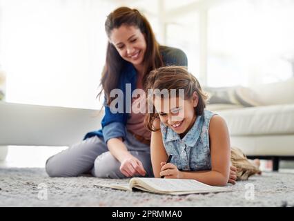 Mutter ist immer eifrig in die Ausbildung ihrer Töchter involviert. Eine Mutter hilft ihrer Tochter bei ihren Hausaufgaben. Stockfoto