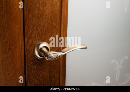 Externer Türgriff ohne Schutzschloss am Holzrahmen. Stockfoto