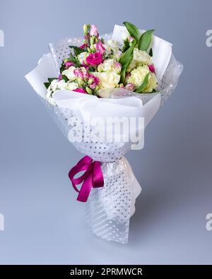 Strauß aus Rosen, Eustoma und Iris auf blauem Hintergrund. Stockfoto