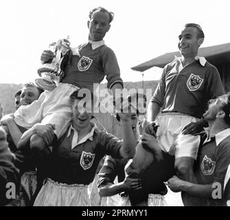 Das Dateifoto vom 02.-05-1953 von Stanley Matthews, der für Blackpool spielte und auf dem Wembley-Spielfeld mit Mannschaftskapitän Harry Johnson (der den Cup hält) den Vorsitz führte, nachdem seine Seite im FA-Cup-Finale vier Tore zu drei gegen Bolton gewonnen hatte. Ausgabedatum: Donnerstag, 27. April 2023. Stockfoto