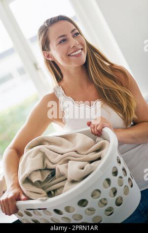 Seine Wäsche Tag. Junge Frau macht Wäsche zu Hause. Stockfoto