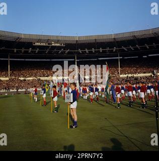 Das Dateifoto vom 11.-07-1966 von Schuljungen, die in den Trikots der konkurrierenden Nationen gekleidet sind, stehen während der Eröffnungszeremonie vor dem England-Uruguay-Spiel auf dem Wembley-Platz. Ausgabedatum: Donnerstag, 27. April 2023. Stockfoto