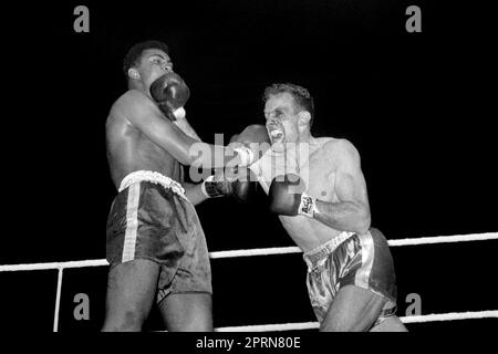 Aktenfoto vom 18.-06-1963 von Cassius Clay (links) und Henry Cooper während ihres Kampfes in Wembley London am 18. Juni 1963. Clay gewann, nachdem er Cooper in der fünften Runde gestoppt hatte, obwohl er in der vierten Runde vom britischen Champion bezwungen wurde. Assius Clay, der später seinen Namen in Muhammad Ali änderte, stellte sich am 18. Juni 1963 in einem Schwergewichtsboxkampf im Wembley Stadium gegen Henry Cooper. Ausgabedatum: Donnerstag, 27. April 2023. Stockfoto