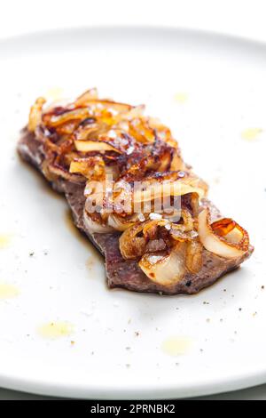 Steak mit karamellisierten Zwiebeln bedeckt Stockfoto