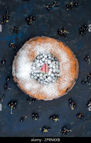 Ein herrlicher Obstkuchen mit Blick von oben, köstlich und rund geformt mit frischen Blaubeeren auf dem dunklen Schreibtisch Kuchen Kekse süßer Zucker Stockfoto