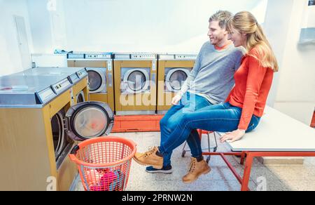 Ein Paar wartet im Waschsalon auf seine Wäsche Stockfoto