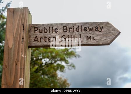 Holzschild für einen öffentlichen Brückenweg zum Arten Gill Viadukt in der Nähe von Sedbergh in den Yorkshire Dales in England, Großbritannien. Stockfoto