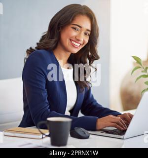 Ich gehe nach Erfolg. Beschnittenes Porträt einer jungen Geschäftsfrau, die an ihrem Laptop arbeitet. Stockfoto