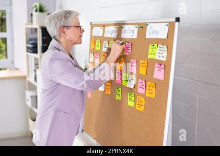 Frau, Die Den Kanban-Plan Schreibt Stockfoto