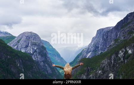 Reiseabenteuer Frau feiert die Arme, die beim Anblick des majestätischen Gletschertals bei der Erkundung der wunderschönen Erde erhoben werden Stockfoto