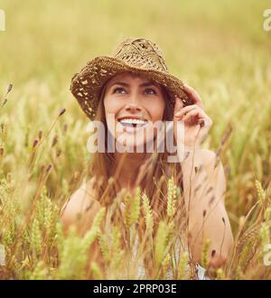 Abenteuer erwartet Sie. Eine junge Frau in einem Weizenfeld. Stockfoto