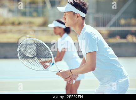 Asiatischer Tennisspieler mit Schläger und Training, Training oder Spiel auf dem Platz. Ernsthafte, fokussierte Fitness-Athleten spielen gemeinsam ein Wettkampf-Doppelspiel als Team, um fit und gesund im Sportverein zu bleiben Stockfoto