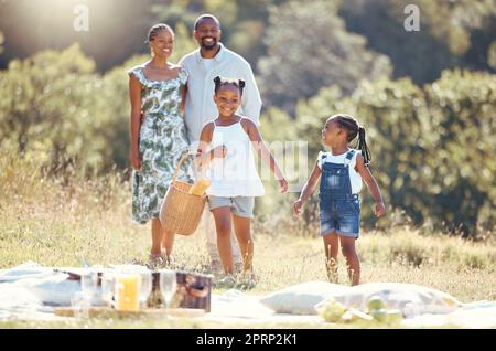 Schwarze Familie, Sommer-Picknick und Kinder haben eine Beziehung zu Eltern während der Pause auf einem abgelegenen Landschaftspark. Lächeln, glücklich und lieben Sie Mutter, Vater oder verspielte und lustige Mädchen bei einem Naturausflug mit Mann und Frau Stockfoto