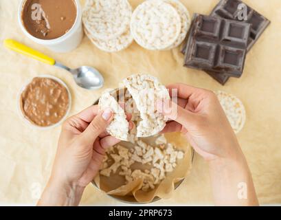 Draufsicht über die Zubereitung eines köstlichen Desserts mit Erdnussbutter und Reiskuchen. Vegane Nachspeise, lecker und gesund. Stockfoto