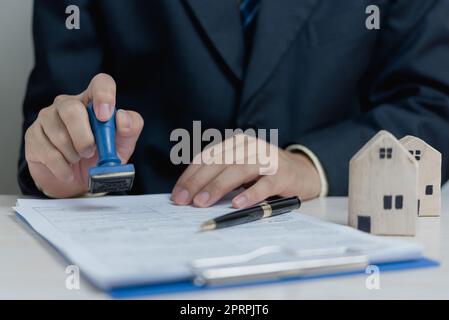 Kauf und Verkauf von Immobilien oder Geld leihen, Bankdarlehen, genehmigte Investments.Businessman Gummi Stempel Dokument auf dem Schreibtisch. Stockfoto