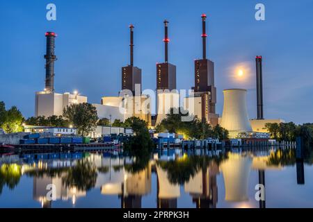 Ein thermisches Kraftwerk in Berlin spiegelte sich nachts in einem Kanal wider Stockfoto