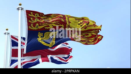 Der Königliche Standard des Vereinigten Königreichs, der den Wind mit der Flagge des Vereinigten Königreichs winkt Stockfoto