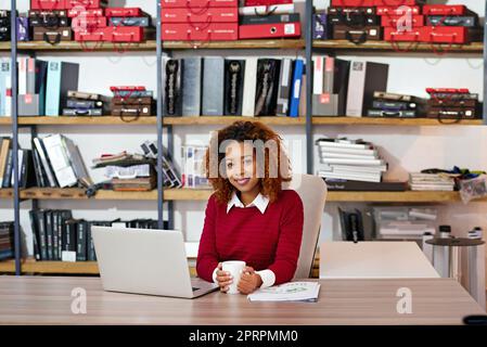 Große Träume erfordern harte Arbeit. Eine junge Frau, die in einem Büro an einem Laptop arbeitet. Stockfoto