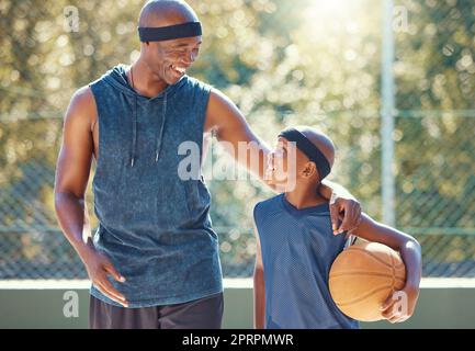 Glücklicher Vater, Sohn und Basketball von Schwarzen, bereit für ein Spiel, unterrichten und lernen vor Gericht. Afrikanischer Mann und Junge in sportlicher Motivation, Training und Workout, die in der Natur zusammen lächeln Stockfoto