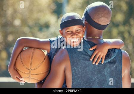 Porträt eines glücklichen Jungen mit Vater und Basketball im Freien nach Training, Workout oder Training. Schwarzer Vater trägt seinen Jungen, nachdem er im Sommer mit einem süßen Lächeln in einem Club oder auf einem Platz Sport gespielt hat Stockfoto