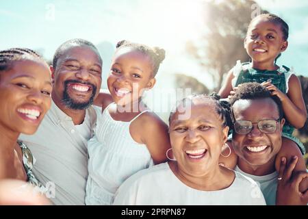 Porträt, glückliche schwarze große Familie und Liebe, während sie im Urlaub, auf Reisen oder im Urlaub lächeln. Abstammung, Afrikaner oder Großeltern, Väter und Mutter mit Kindern zusammen in der strahlenden Sonne oder im Sonnenschein. Stockfoto