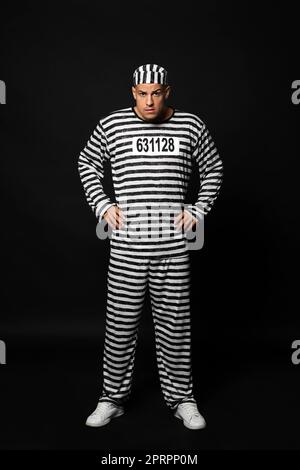 Gefangener in gestreifter Uniform auf schwarzem Hintergrund Stockfoto
