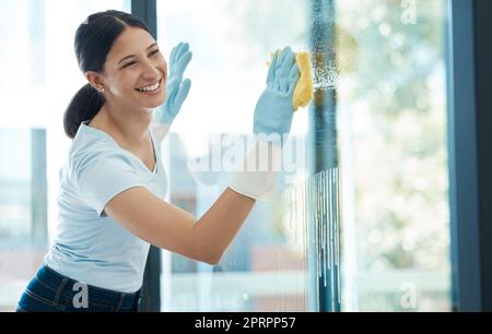 Reinigungs-, Fenster- und Servicefrau mit Glaswasser oder chemischer Flüssigkeit mit einem Lächeln für einen glücklichen Job oder eine glückliche Karriere. Sauberes Arbeiten in modernen Wohnungen oder Gebäuden und Schmutzwischen mit Schwamm Stockfoto