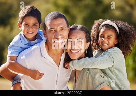 Glücklich, Familie und Lächeln einer mutter, eines Vaters und Kinder in einem Naturpark, die im Sommer Spaß haben. Porträt von Eltern und jungen Kindern aus Mexiko, die gemeinsam im Freien mit Jugendbetreuung spielen Stockfoto