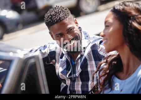 Betrachten Sie es als ein Abenteuer. Ein glückliches junges Paar, das an einem hellen Sommertag in einem Cabrio fährt. Stockfoto