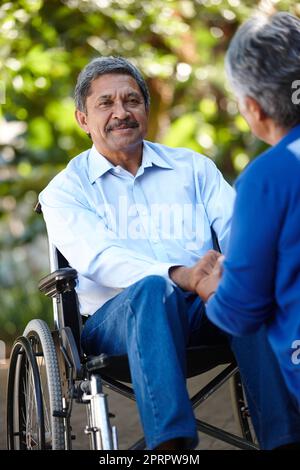 Unterstützend, durch alles. Ein Seniorenpaar im Freien reden. Stockfoto