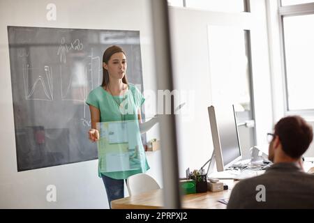 Sie hat alle Informationen, die sie zum Erfolg braucht. Eine junge Designerin präsentiert ihre Geschäftsstrategie. Stockfoto