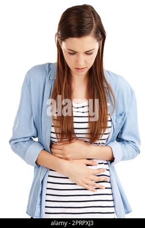 Das fühlt sich nicht gut an. Studioaufnahme einer attraktiven jungen Frau mit Bauchschmerzen vor weißem Hintergrund. Stockfoto