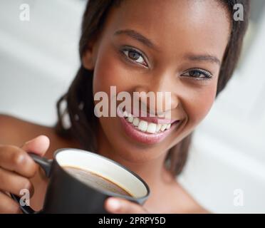 Starten Sie ihren Morgen. Eine junge ethnische Frau genießt eine Tasse Kaffee. Stockfoto