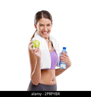 Ich esse alles, was die Natur freiwillig gibt. Eine schöne junge Frau mit einem frischen grünen Apfel und einer Flasche Wasser. Stockfoto