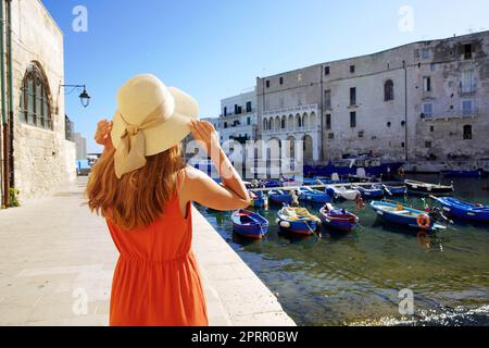 Tourismus in Apulien, Italien. Rückansicht der schönen Mode Mädchen genießen Blick auf Monopoli alten Hafen in Apulien, Italien. Urlaub Europe im Sommer. Stockfoto