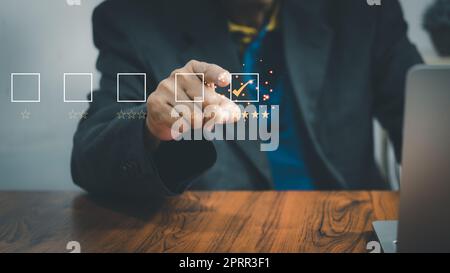 Geschäftsleute nutzen Laptop-Computer Umfrage und bewerten Zufriedenheit geben eine 5-Sterne-Form auf einem virtuellen digitalen Bildschirm Zufriedenheit Bewertung. Umfragekonzept. Stockfoto